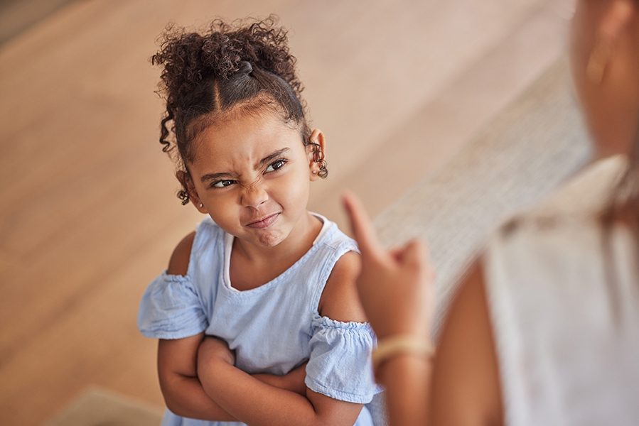 Angry child and tantrum discipline conflict for attitude problem in home with stressed mother. Young girl frustrated, unhappy and moody at disappointed adult punishment for negative behaviour
