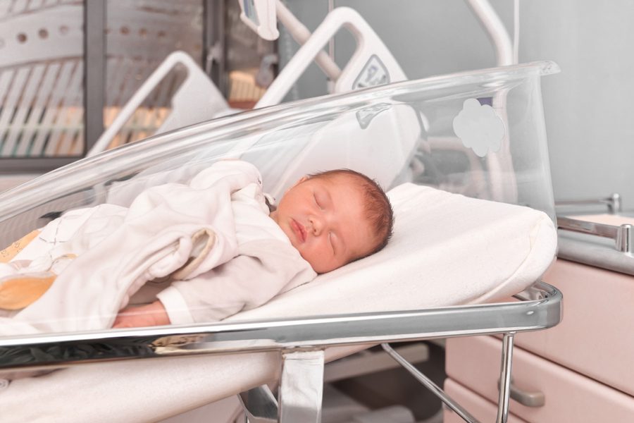 Newborn baby sleeping in a hospital bed