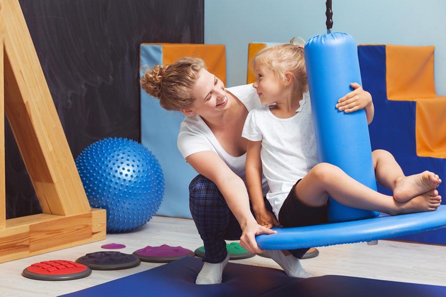 child-sits-chair-with-blue-foam-roller