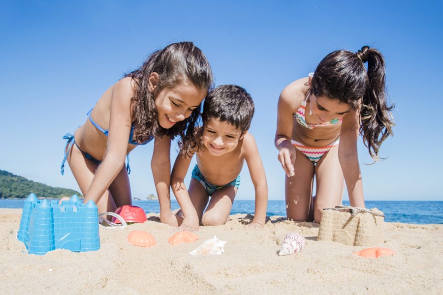 criancas-felizes-brincando-na-praia