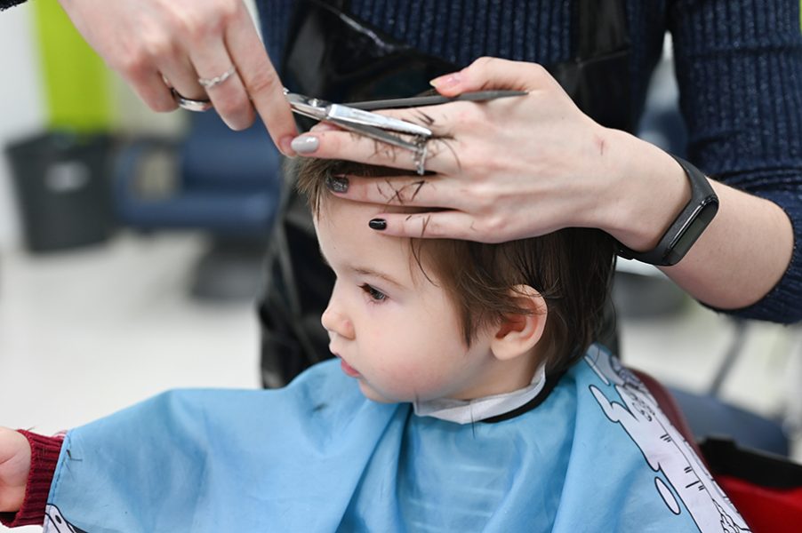 Haircut boy 0-1 years. The first haircut of the child at the hairdresser. Baby haircut toddler
