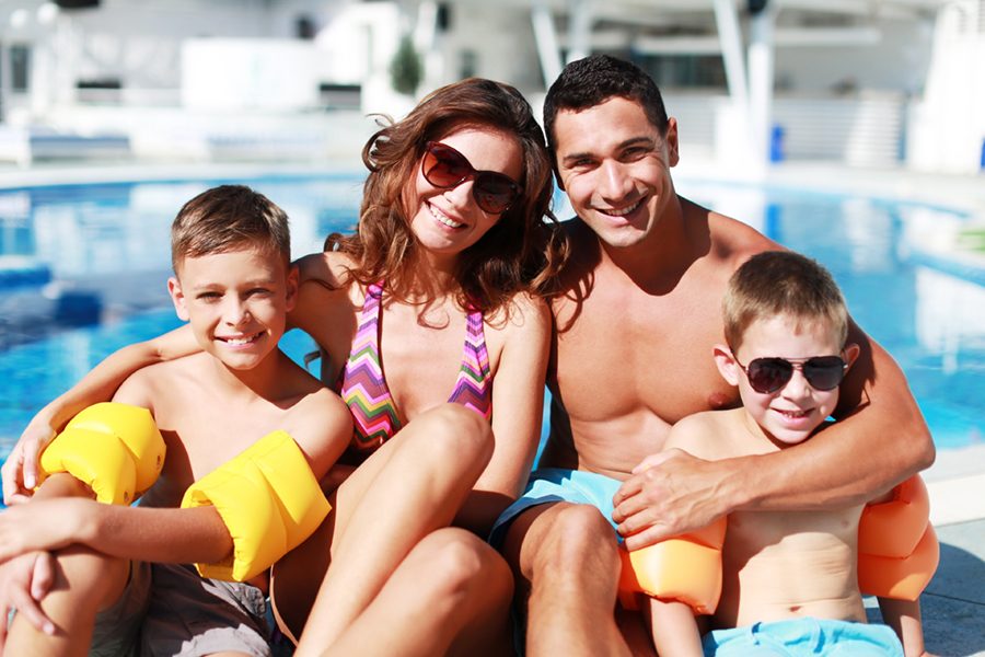 Happy family playing in swimming pool. Summer vacation concept