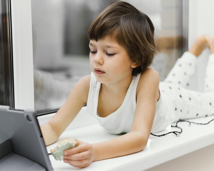 kid-indoors-looking-tablet