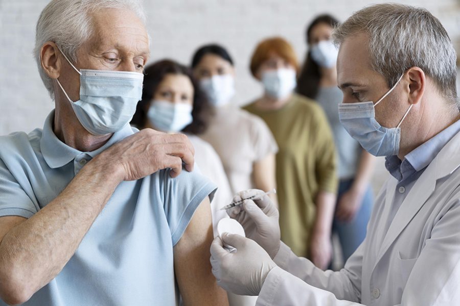 man-getting-vaccine-shot-by-doctor-with-medical-mask