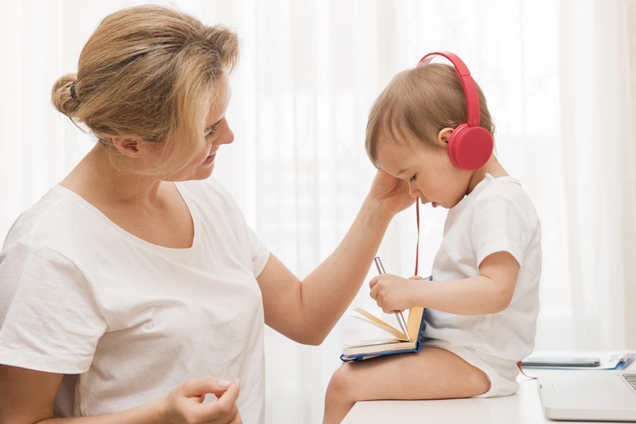 mid-shot-cute-baby-desk-with-headphones-mother