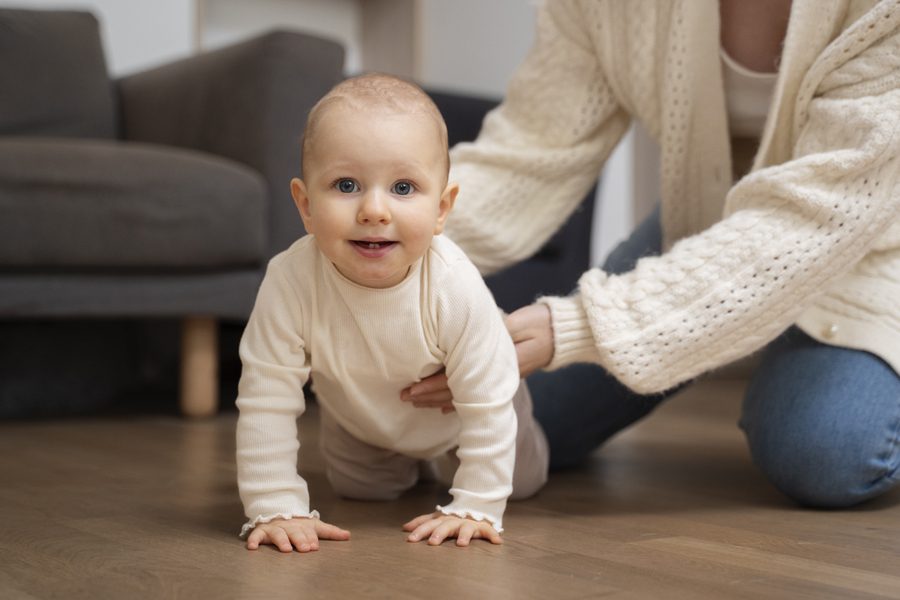 parent-helping-baby-crawl-high-angle