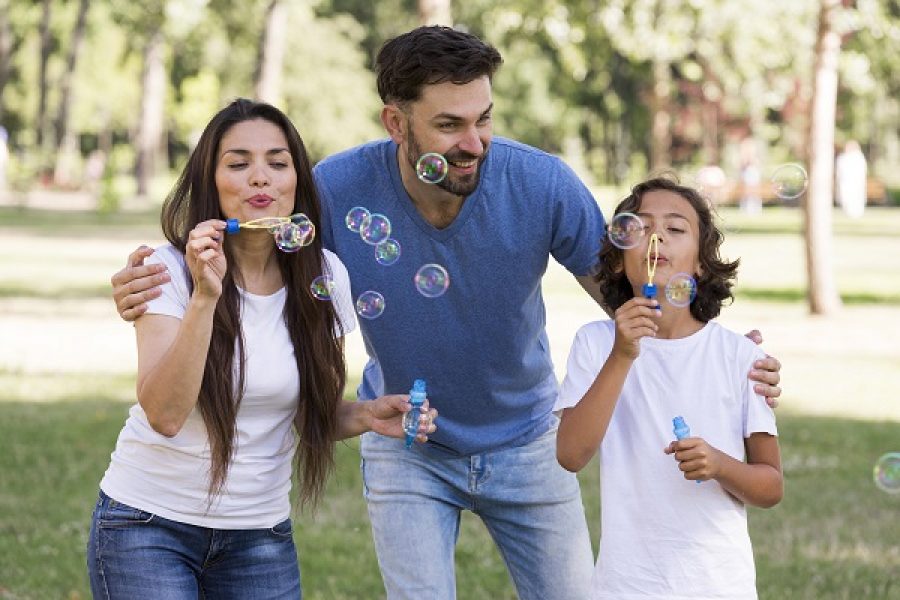 parents-boy-having-great-time-blowing-bubbles-park