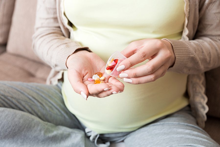Pregnant woman with pills in hand, healthcare concept, medicine during pregnancy.