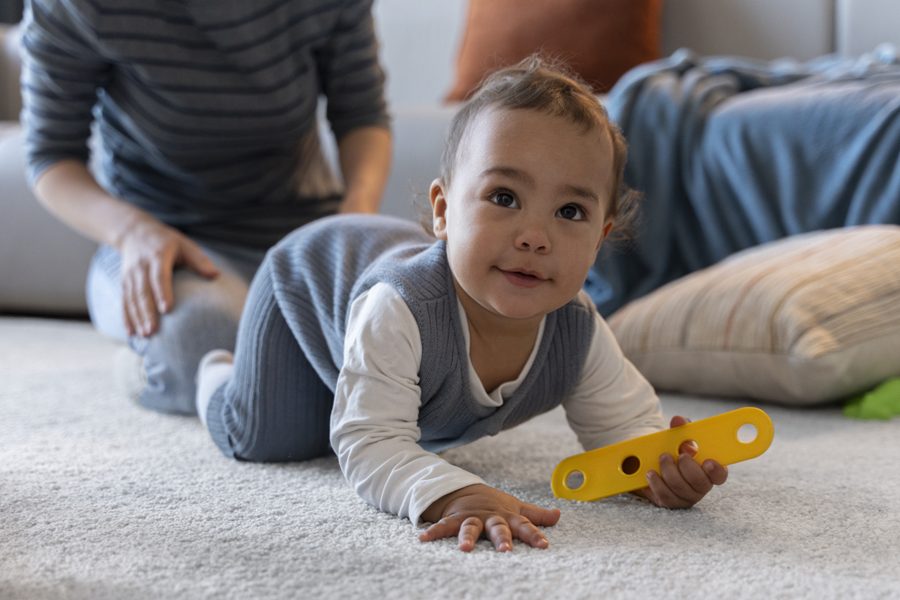 smiling-baby-crawling-with-toy-his-hand