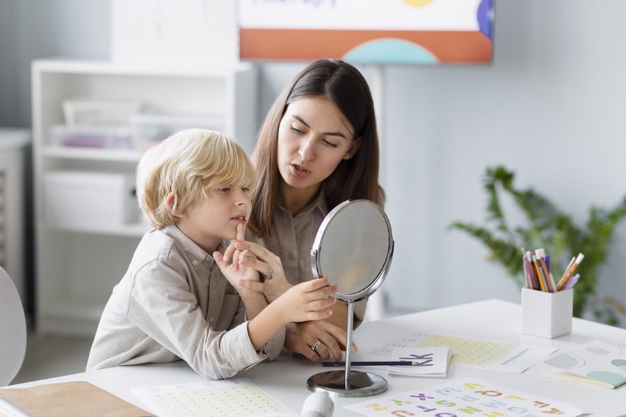 woman-doing-speech-therapy-with-little-boy-her-clinic