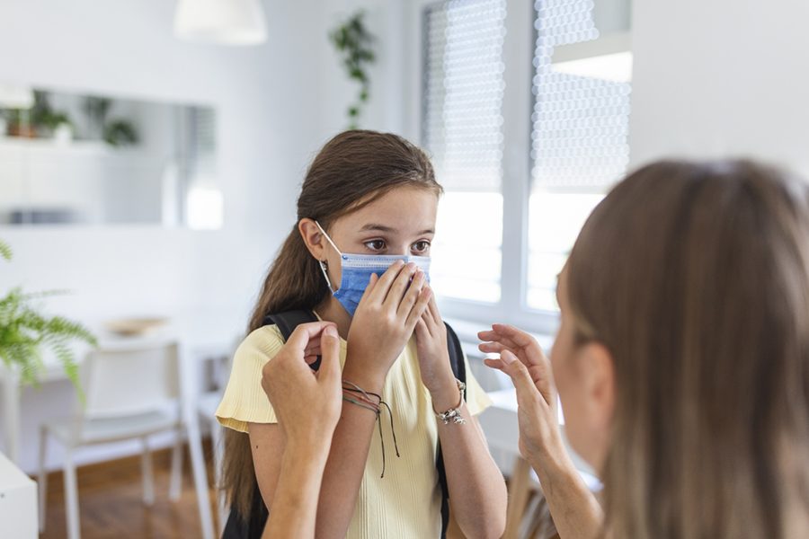 Young mother help her daughter wearing medical mask to prepare go to school. Avoiding Covid-19 or coronavirus outbreak. Back to school